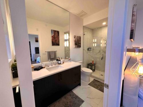 een badkamer met een wastafel, een toilet en een douche bij Lake Okanagan Oasis - Rooftop Patio in West Kelowna