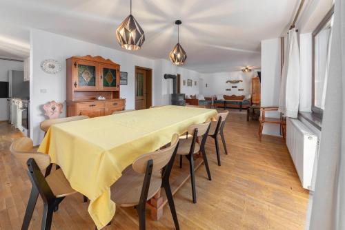 a dining room with a yellow table and chairs at Holiday Home Kersnik in Bohinj