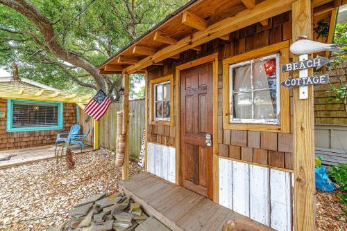a wooden cabin with an american flag on the porch at Cape Fear at Island Breeze of CB in Carolina Beach
