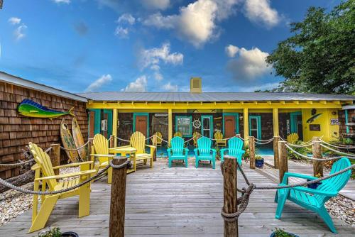 a deck with chairs and tables in front of a house at Cape Fear at Island Breeze of CB in Carolina Beach
