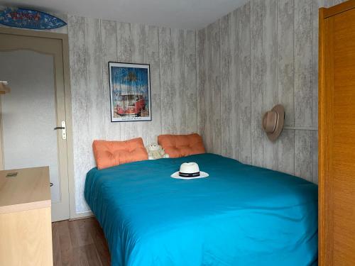 een slaapkamer met een blauw bed met een hoed erop bij maison avec beau jardin arboré in Torcy
