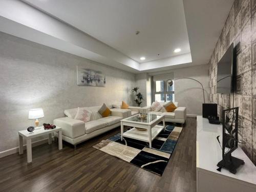 een woonkamer met een witte bank en een tafel bij Spacious High floor sea view luxury family Unit-Sea View in Dubai