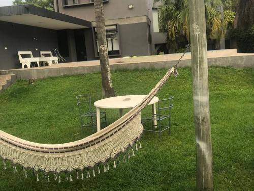 a hammock in a yard with a table and chairs at Casa de Huéspedes La Escondida in Yerba Buena