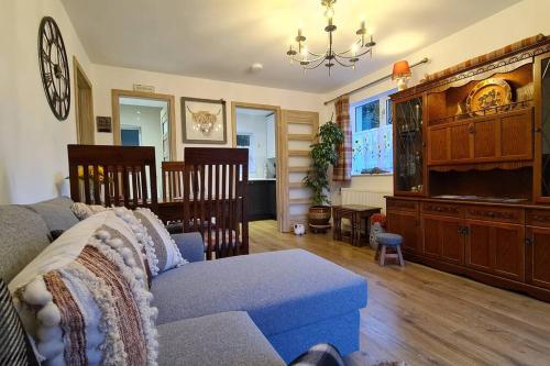 a living room with a couch and a dining room at Northlea-Scottish style cottage in Inverness