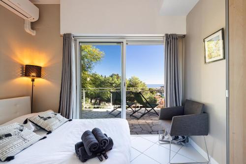 - une chambre avec un lit et une vue sur une terrasse dans l'établissement VILLA CRUG HYWEL - VILLEFRANCHE-SUR-MER, à Villefranche-sur-Mer