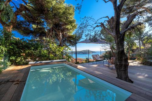 a swimming pool on the deck of a house with a tree at VILLA CRUG HYWEL - VILLEFRANCHE-SUR-MER in Villefranche-sur-Mer