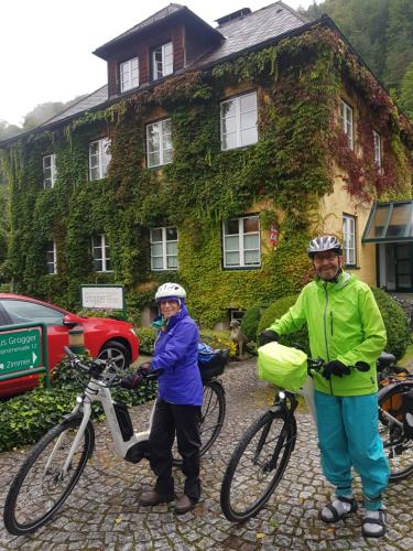 a man and a woman standing next to their bikes at Gästehaus Grogger in Weyer Markt