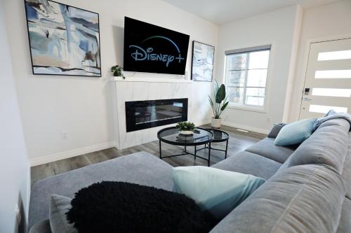 ein Wohnzimmer mit einem Sofa und einem Kamin in der Unterkunft Three King Beds,Central A/C,Fireplace,Park,Disney+ in Edmonton
