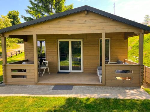 a large wooden cabin with a deck at Arenda Apartamenty&Domki całoroczne in Sieraków