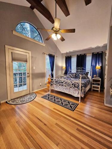 ein Wohnzimmer mit einem Bett und einem Deckenventilator in der Unterkunft Charming Two Story Country Style Loft with Balcony in Houston