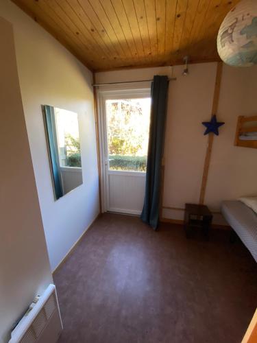 a room with a window and a bed and a mirror at Charmant logement à la campagne, au calme in Manhac