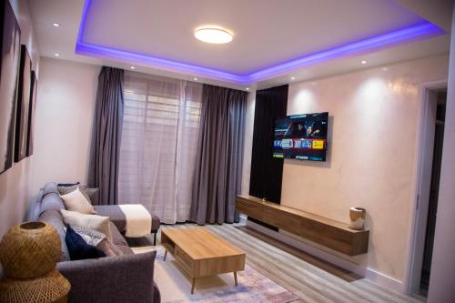 a living room with a couch and a tv at BeHomu Apartments in Kira