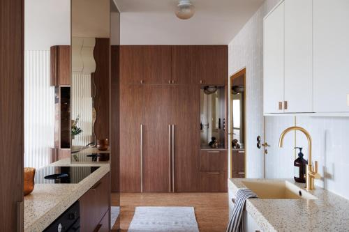 eine große Küche mit Holzschränken und einem Waschbecken in der Unterkunft Vintage Glamour Suite, parveke, parkkipaikka in Helsinki