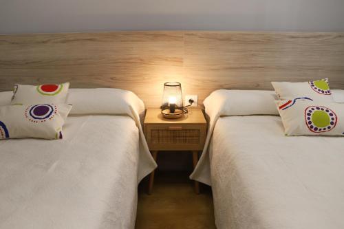 twee bedden naast elkaar in een kamer bij APARTAMENTO TURISTICO EL CANALIZO in Candelario