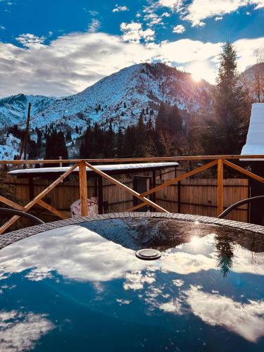 a hot tub with a snow covered mountain in the background at Eywa House in Kamenskoye Plato