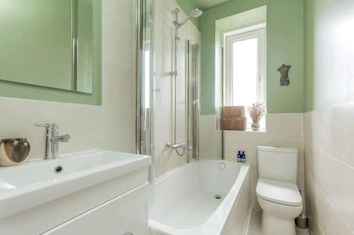 a white bathroom with a sink and a toilet at Vibrant and Spacious 2BD flat for 4 in Edinburgh in Edinburgh