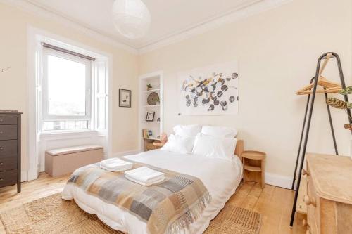 a white bedroom with a bed and a window at Vibrant and Spacious 2BD flat for 4 in Edinburgh in Edinburgh