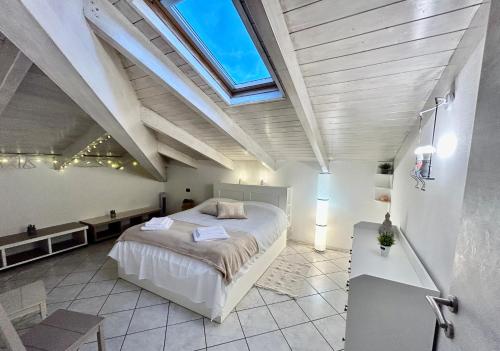 a bedroom with a large bed and a skylight at L’Angolo di Pace in Massa Lombarda