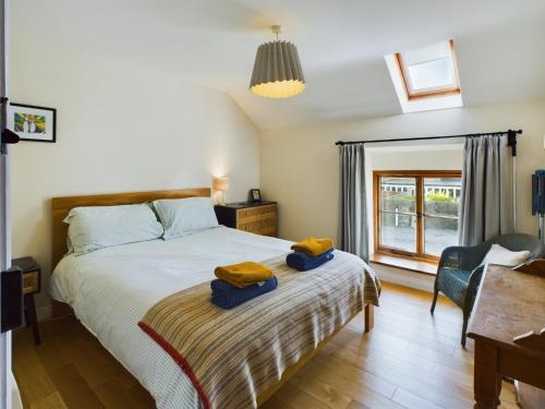 1 dormitorio con 1 cama con 2 toallas en Cosy Stone Cottage in Llanarthney nr Carmarthen, en Llanarthney