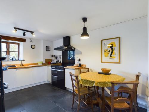 a kitchen with a table and a table and chairs at Cosy Stone Cottage in Llanarthney nr Carmarthen in Llanarthney