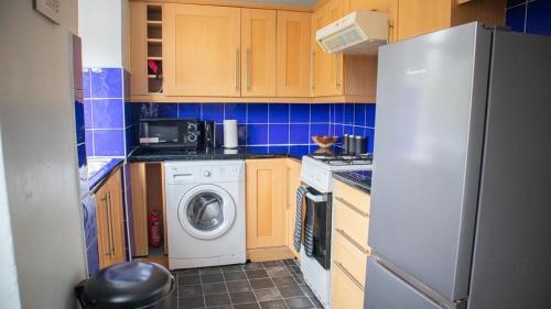 a kitchen with a refrigerator and a washing machine at HILLTOP PLACE SUITES , Parkway M1 J33 in High Hazels