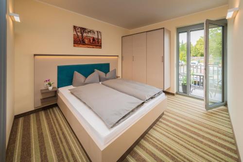 a bedroom with a large bed and a balcony at ELLY Hostel in Freiberg