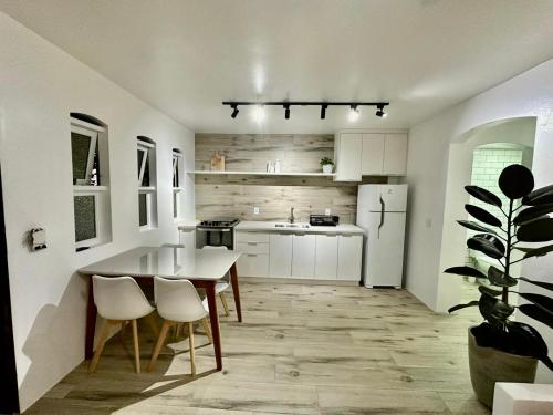 eine Küche mit einem Tisch und einem weißen Kühlschrank in der Unterkunft Apartamento estilo Chalé com piscina in Ubatuba
