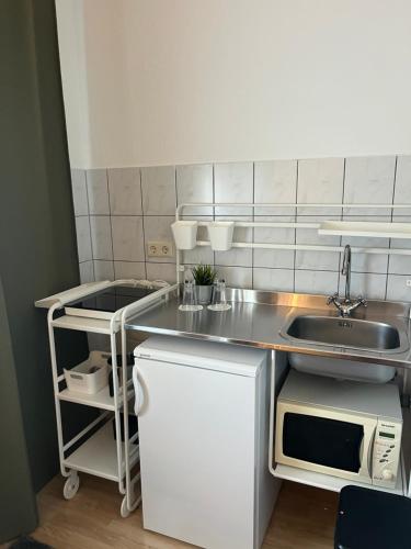 a small kitchen with a sink and a microwave at Pension Stadt Mannheim in Mannheim