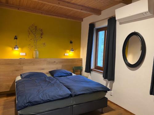 Schlafzimmer mit einem Bett mit einem Spiegel und einem Fenster in der Unterkunft Fidler in Rozvadov