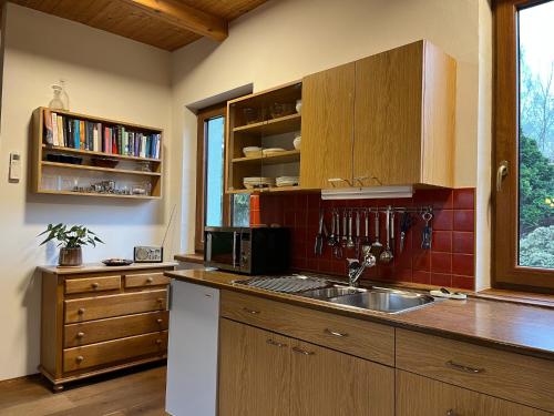 una cocina con armarios de madera y fregadero en Fidler, en Rozvadov