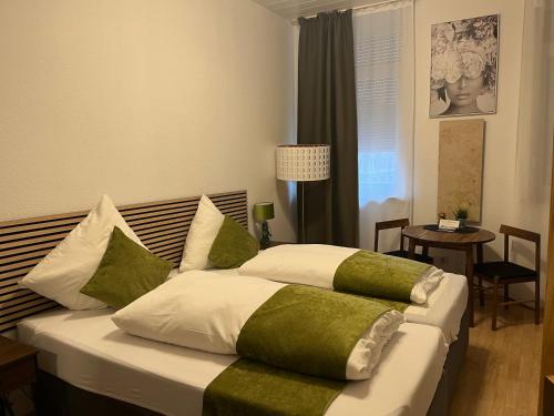una camera da letto con un grande letto con cuscini verdi e bianchi di Pension Stadt Mannheim a Mannheim