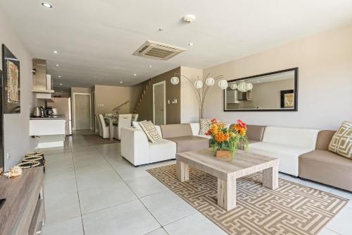 una sala de estar con sofás blancos y una mesa. en Large Luxury apartment on Palm Beach, en Palm-Eagle Beach