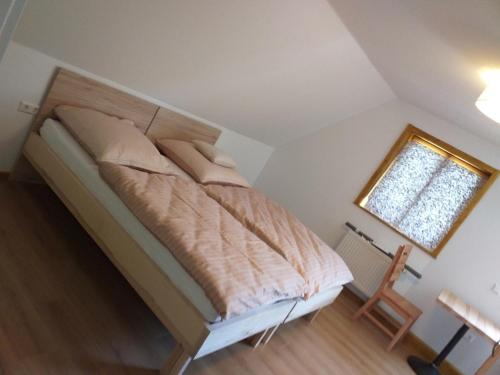 a bedroom with a large bed with a window at Landcafe SIMA & Zimmervermietung in Forheim