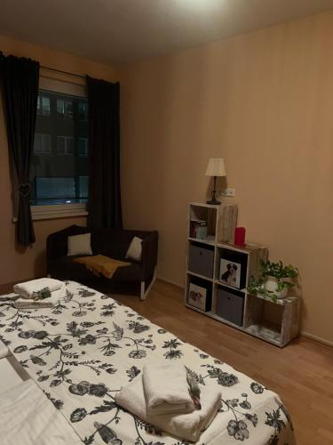 a bedroom with a bed and a chair and a window at Innenstadt Lübeck Ferienwohnung in Lübeck