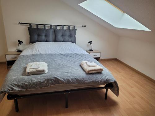 een slaapkamer met een bed met twee handdoeken erop bij Appartement T3 60m2 calme in Morez