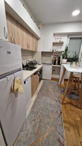 a kitchen with a white refrigerator and a table at Kris apartments in Skopje