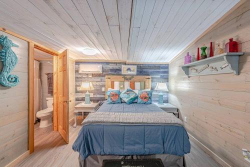 een slaapkamer met een bed in een blokhut bij Something Fishy at Island Breeze of CB in Carolina Beach