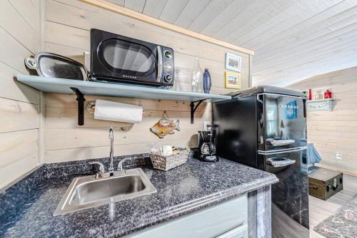 a kitchen with a sink and a microwave at Something Fishy at Island Breeze of CB in Carolina Beach