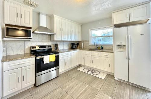 a kitchen with white cabinets and a white refrigerator at Lovely Home 30MIN to Berkeley, SF, Napa in Pinole