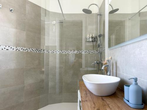 uma casa de banho com um chuveiro e um lavatório branco em MAISON NOEL em Trieste