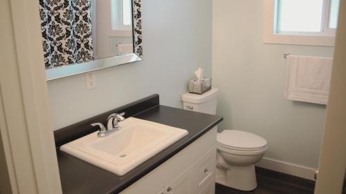 a white bathroom with a sink and a toilet at Stoneshire Guesthouse in Clearwater