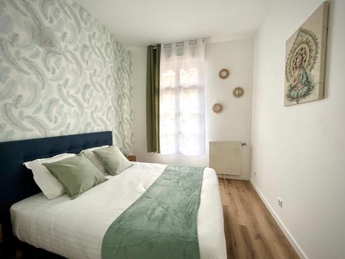 a bedroom with a bed with a blue headboard and a window at Central Park in Serris