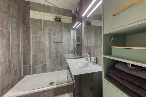 a bathroom with a sink and a tub and a shower at L'industriel - 2'mn du métro - aux portes de Paris in Saint-Mandé