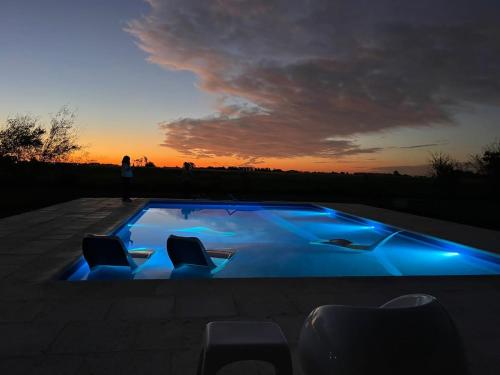 a person standing next to a swimming pool at sunset at El campito in Capilla del Señor