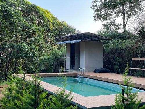una piscina en un jardín con una casa en 900 Woods Wayanad Eco Resort - 300 Acre Forest Property Near Glass Bridge en Meppādi