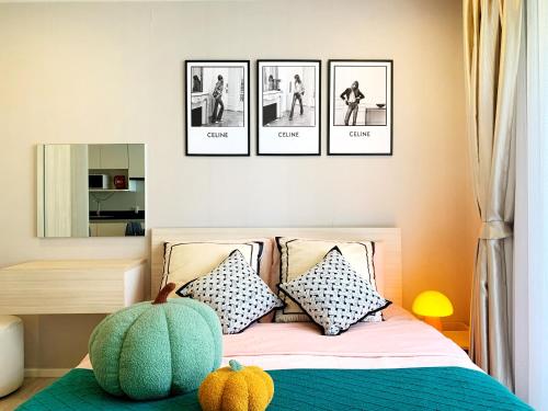 a bedroom with a bed with four pictures on the wall at CM Design Space in Ninman MAYA in Chiang Mai