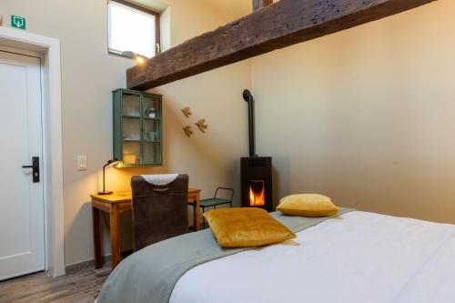 - une chambre avec un lit et un poêle à bois dans l'établissement La Bergerie, à Leuze-en-Hainaut