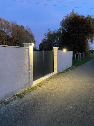 uma cerca com um portão com luzes em La maison des rosiers au bord du Loir 