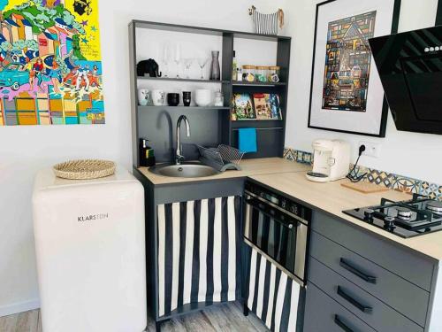 a small kitchen with a sink and a refrigerator at L’Appar(T) du Grand Bois - Jacuzzi - in Soucelles