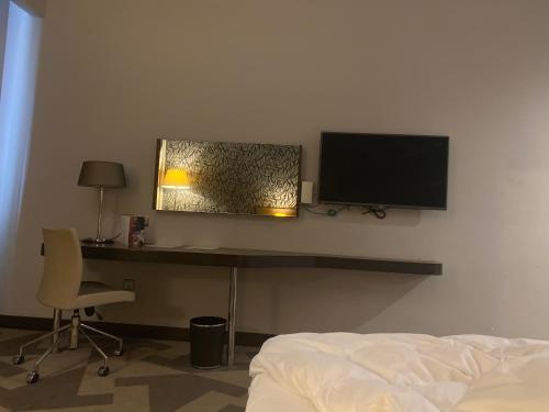 a bedroom with a desk with a television and a bed at Entre Mer et Lac de la Goulette in La Goulette